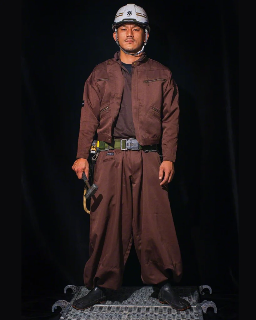 Tobi worker in traditional Japanese workwear, featuring loose-fitting trousers (tobi pants) and a jacket, showcasing the unique and functional style of Japanese construction fashion.